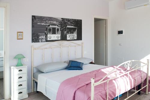 a bedroom with a white bed with a pink blanket at Al Giorgione in Caselle