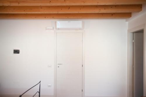 a room with a white wall and a wooden ceiling at Al Giorgione in Caselle