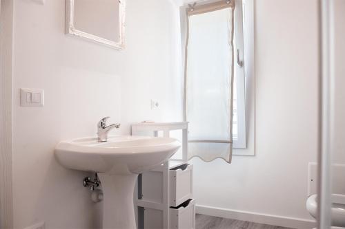 a white bathroom with a sink and a mirror at Al Giorgione in Caselle