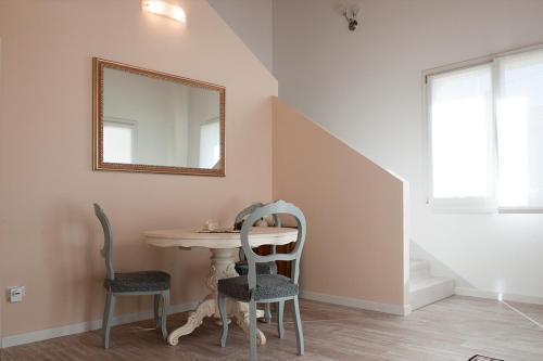 a table with two chairs and a mirror on a wall at Al Giorgione in Caselle