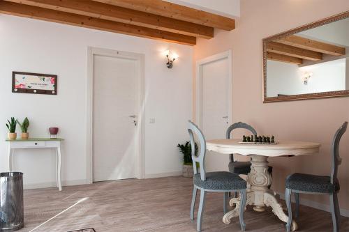 Un comedor con una mesa y sillas y un espejo. en Al Giorgione, en Caselle
