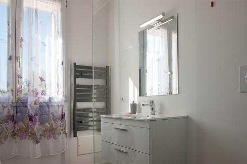 a white bathroom with a sink and a mirror at Al Giorgione in Caselle