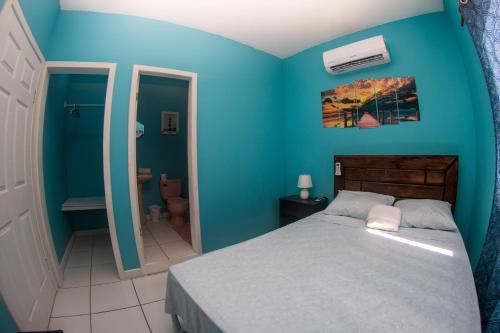 a blue bedroom with a bed and a bathroom at Bliss on the Bay in West End