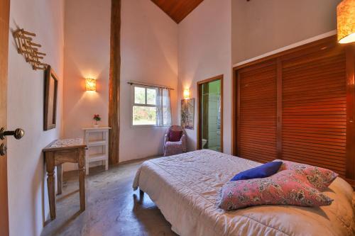 a bedroom with a bed and a window at Casa Estrelada in São Bento do Sapucaí