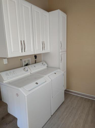 a white laundry room with a washer and dryer at Rancher's Capitol Lodge in Cheyenne