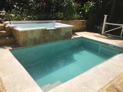 a swimming pool with a hot tub in a backyard at FLOR DE PARAISO BUNGALOWS in Montezuma