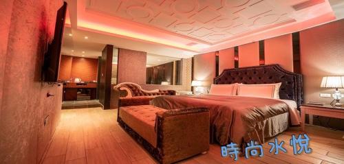 a bedroom with a bed and a chair and a couch at Shuiyue Boutique Motel in Dali