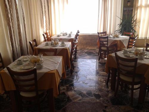 una sala da pranzo con tavoli, sedie e una finestra di Hotel Petras Beach a Sitia