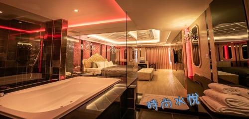 a large bathroom with a tub and a bedroom at Shuiyue Boutique Motel in Dali