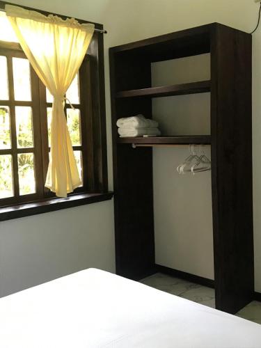 a bedroom with a window with a yellow curtain at FLOR DE PARAISO BUNGALOWS in Montezuma