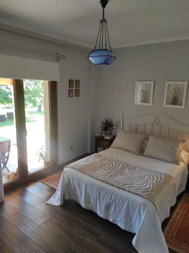 a bedroom with a bed and a pendant light at Casas Cuncheiro in Canduas