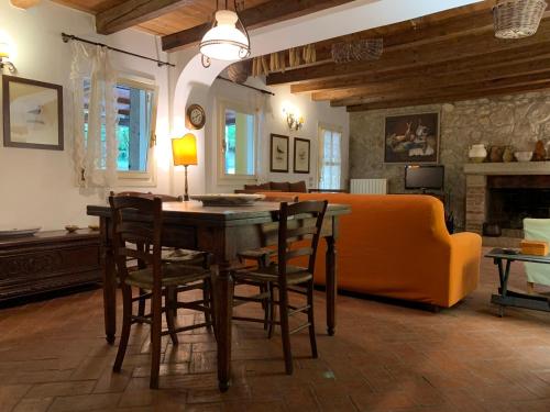 ein Wohnzimmer mit einem Tisch, Stühlen und einem Sofa in der Unterkunft Euganean Hills Natural Park: Casale Il Boschetto in Torreglia