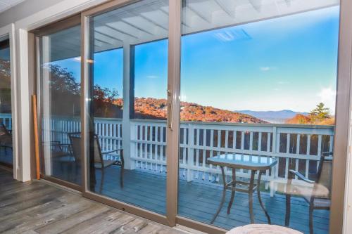 a screened porch with a table and chairs on a deck at Gunstock Inn & Suites in Gilford