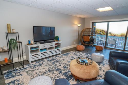 ein Wohnzimmer mit einem TV und einem Sofa in der Unterkunft Gunstock Inn & Suites in Gilford