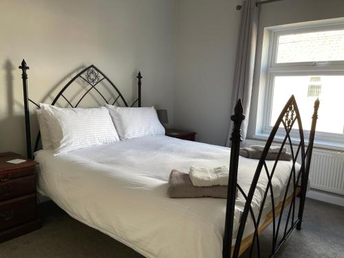 ein Schlafzimmer mit einem großen Bett mit weißer Bettwäsche und Kissen in der Unterkunft Dorchester central flat in Dorchester