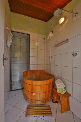 a wooden tub in a bathroom with a shower at Casa Estrelada in São Bento do Sapucaí