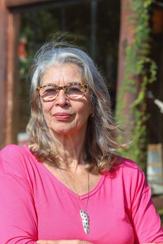 an older woman wearing glasses and a pink shirt at Casa Estrelada in São Bento do Sapucaí