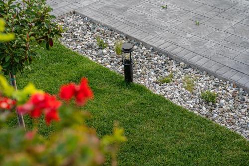 a garden with a light pole in the grass at Meteora vibes in Kalabaka