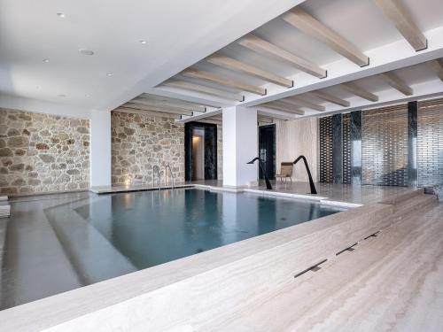 una piscina en una habitación con una pared de piedra en The Tanneries Hotel & Spa en La Canea