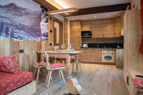 a kitchen and living room with a table and chairs at AG Apartments Livigno centro in Livigno