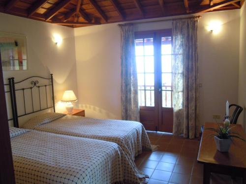 ein Schlafzimmer mit einem Bett und einem großen Fenster in der Unterkunft Casas-Bungalows Los Pajeros in Breña Baja