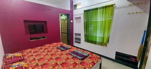 a bedroom with a bed with flowers on it at Adarsh Niwas in Malvan