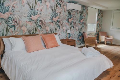 a bedroom with a white bed with a floral wallpaper at Penny's Motel in Thornbury