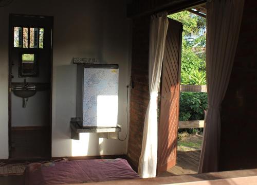 a door to a room with a window and a bed at Hostel do Ceu in Pipa
