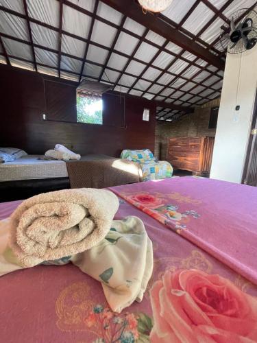 a room with a bed with towels on it at Hostel do Ceu in Pipa