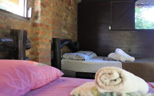 a room with two beds and a window at Hostel do Ceu in Pipa