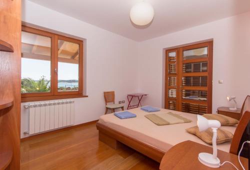 a bedroom with a bed and a table and a window at Villa Marija in Medulin