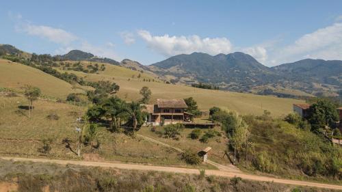 a house on the side of a hill with mountains at Casa Estrelada in São Bento do Sapucaí