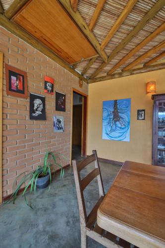a dining room with a table and a brick wall at Casa Estrelada in São Bento do Sapucaí