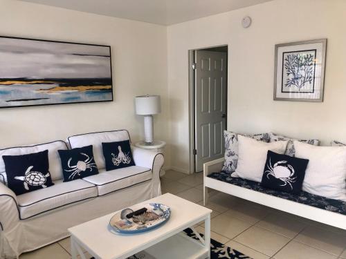 a living room with two couches and a table at Gorgeous Beachy Chic Condo in Key Biscayne in Miami