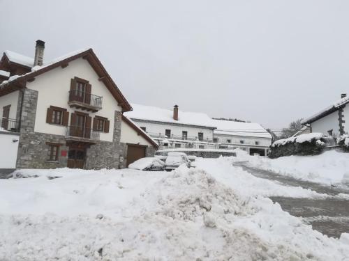 a pile of snow in front of a house at Pirinargi Apartamento in Abaurrea Alta