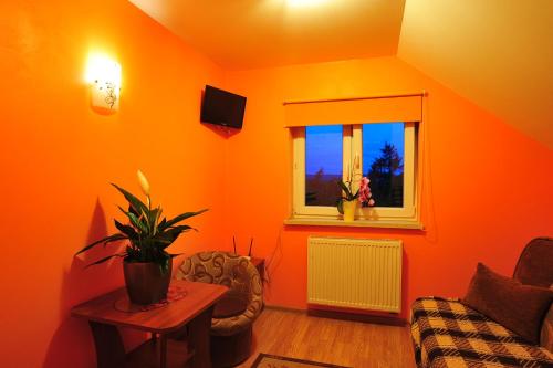 an orange room with a couch and a window at Agroturystyka ZIELONA ZAGRODA w Kosztowej in Dubiecko