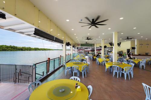 un restaurante con mesas amarillas y sillas en un barco en Hotel Le-Shore, en Kuala Selangor