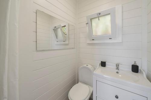 a white bathroom with a toilet and a sink at Casa da Rocha de Baixo by An Island Apart in Santana