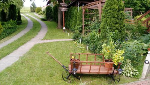 a garden with a bench with flowers and plants at Agroturystyka ZIELONA ZAGRODA w Kosztowej in Dubiecko