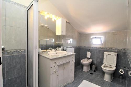 a bathroom with a toilet and a sink and a toilet istg at Charm Penthouse Ocean View in Calheta