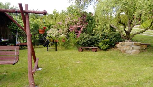 a garden with a bench and a table and a tree at Agroturystyka ZIELONA ZAGRODA w Kosztowej in Dubiecko