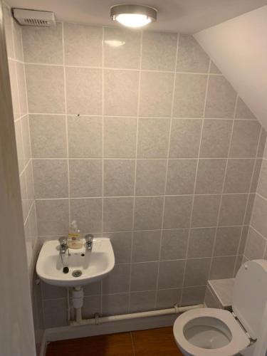 a bathroom with a sink and a toilet at Private Rooms In A Cheerful 4-Bedroom Town House in Broughton