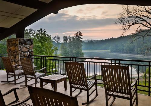 a porch with chairs and a view of a lake at Kanuga Inn & Lodging in Hendersonville