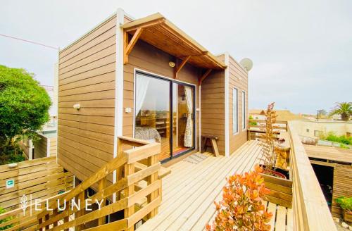 a small house with a wooden deck at ELUNEY Pichilemu in Pichilemu