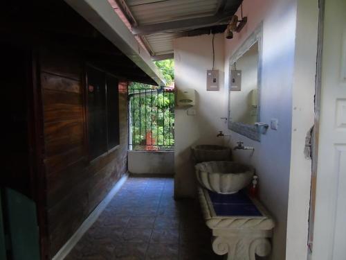 a bathroom with a sink and a toilet and a window at Hostal Villas Mexico in San Juan del Sur