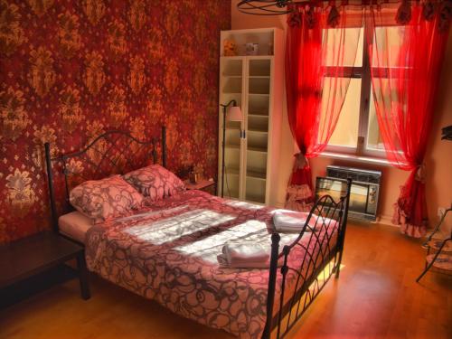 1 dormitorio con 1 cama en una habitación con paredes rojas en Stela's Apartments - Vysehrad, en Praga