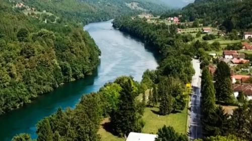 a river flows through a village in a valley at Etno selo Bok in Vrhpolje