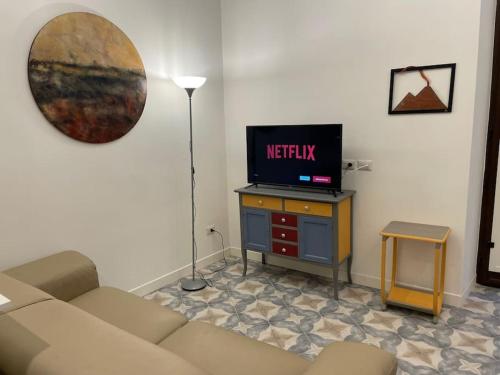 uma sala de estar com um sofá e uma televisão em Casa Luciano al San Carlo em Nápoles