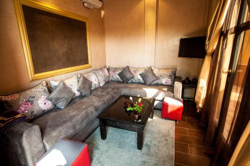 a living room with a couch and a table at ApartHotel Nzaha in Tahannout