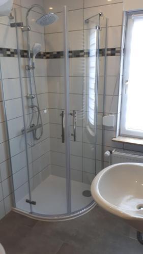 a shower with a glass door next to a sink at Ferienhaus am Mittelberg in Nordhausen